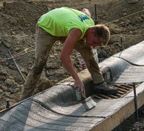 Man brushing a newly constructed concrete curb