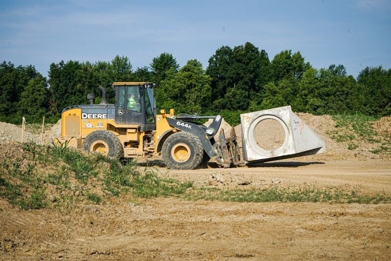 A construction vehicle moves a large cement object