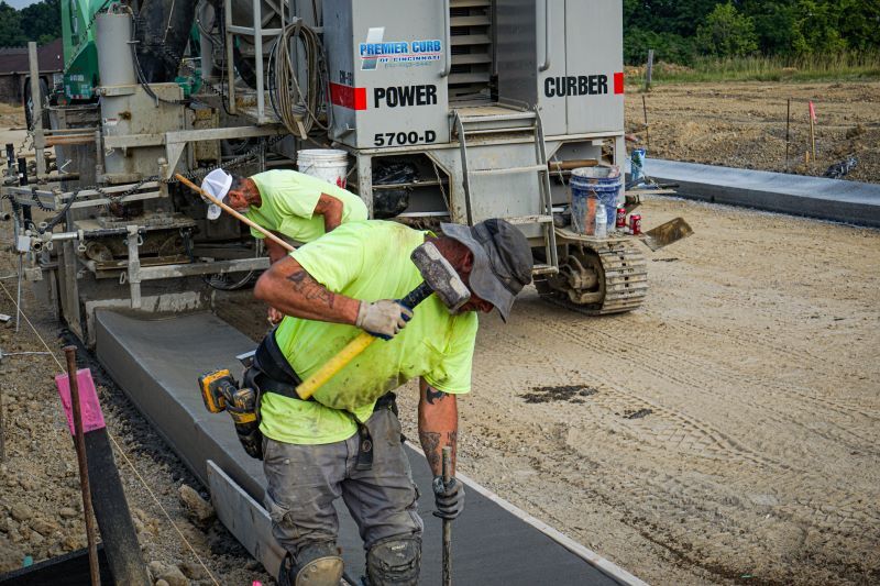 A worker uses a sledge hammer to river rebar into the ground