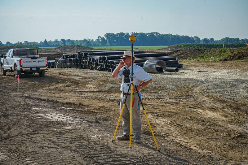 Man standing watching construction site. 