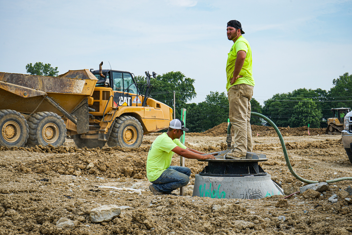 Two men working on drainage system