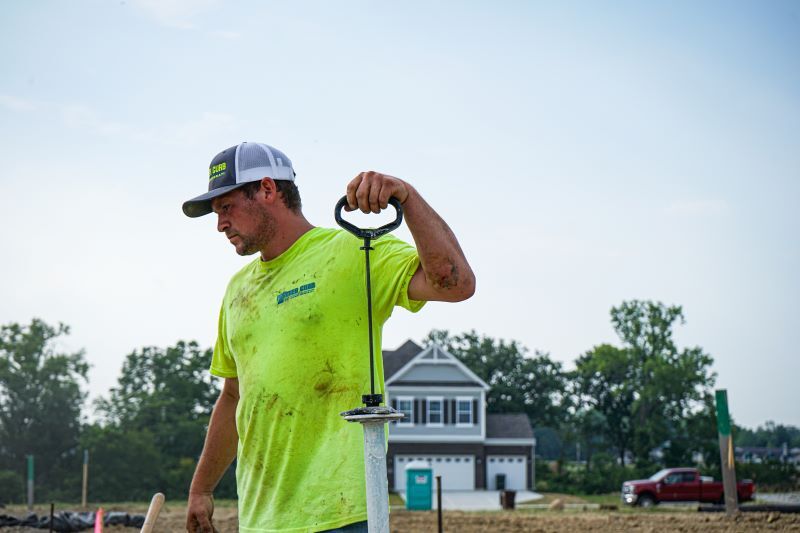 Man standing holding a tool. 