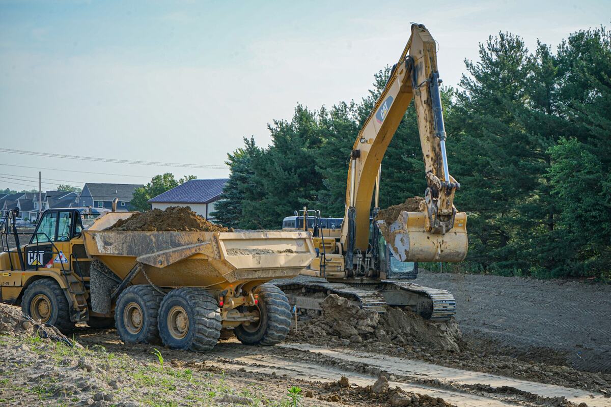 Construction dump truck and excavator sitting on construction site