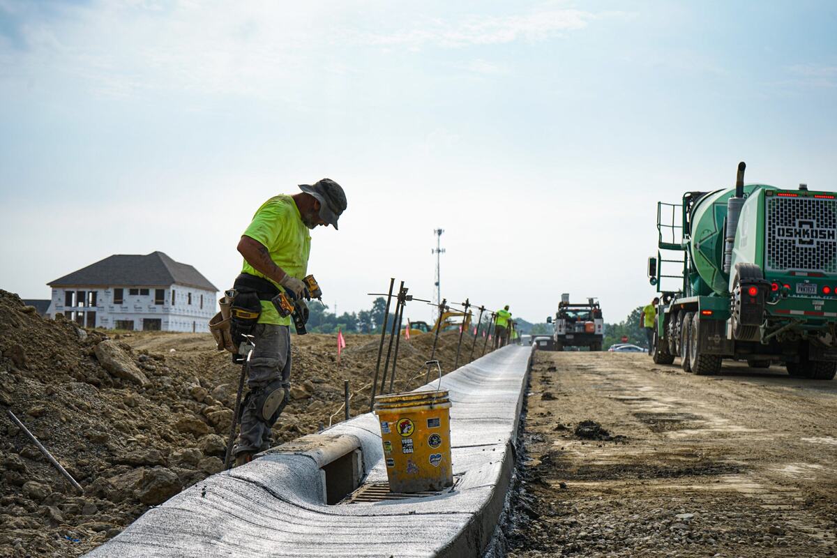 Man standing on side of newly constructed roadway